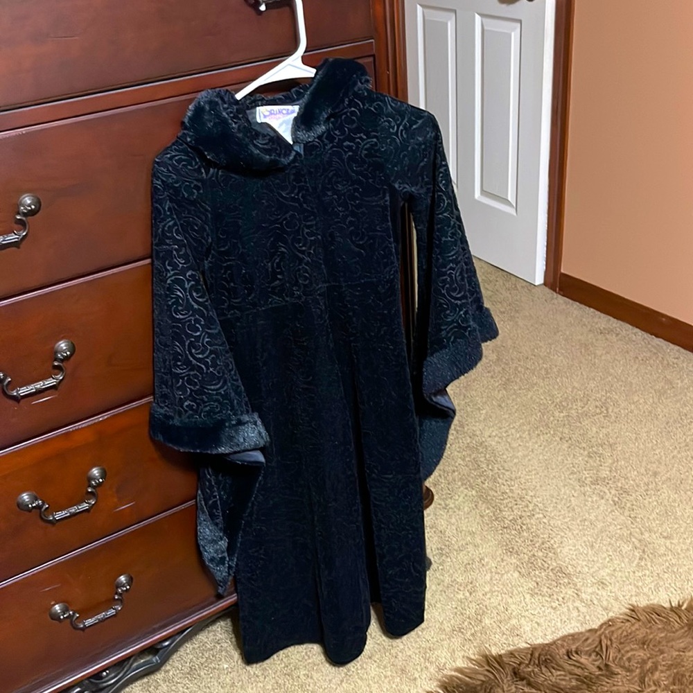 Black velvety jacket with long wide sleeves.